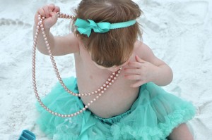 baby in green tutu looking down