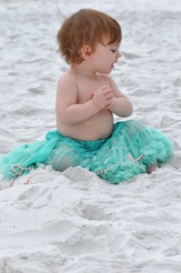 baby in green tutu smiling